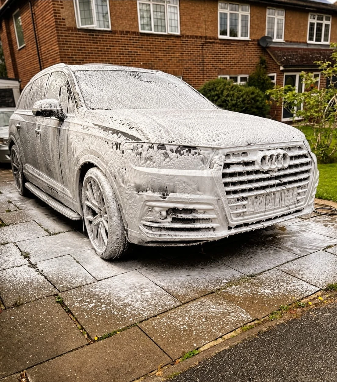 Audi Q7 during snow foam pre-wash, viewed from the front