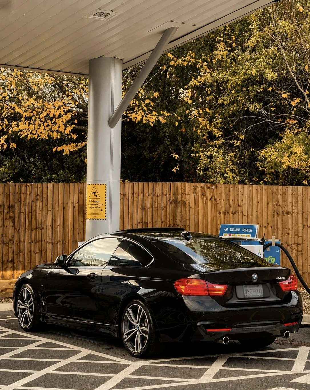 Black BMW 440i coupe after detailing, viewed from the rear three-quarter